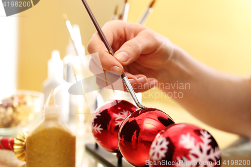 Image of Female hand painted Christmas bauble in Christmas decorations factory 