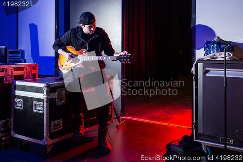 Image of Roadie tuning a guitar for the guitarist