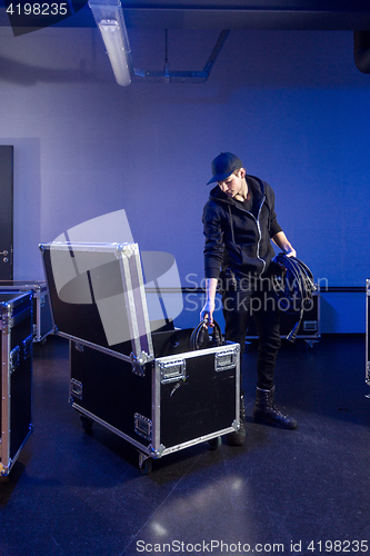 Image of Roadie picking some cables out of a flightcase