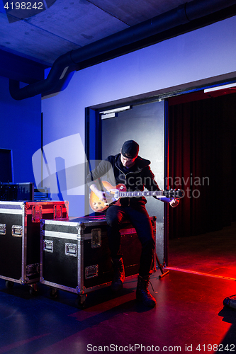 Image of Roadie tuning a guitar for the guitarist