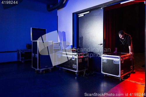 Image of Roadie rolling a flightcase off the stage