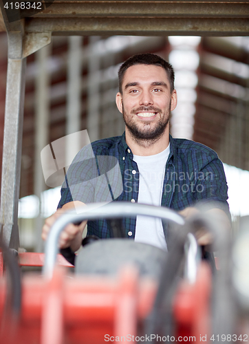 Image of man or farmer driving tractor at farm