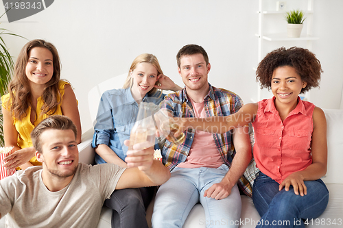 Image of happy friends with popcorn and beer at home