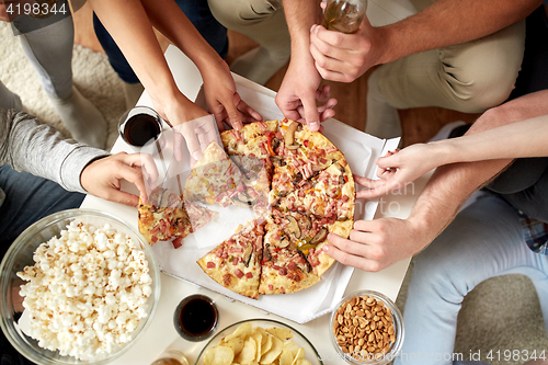 Image of close up of people taking pizza slices at home