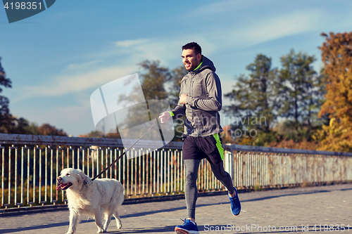 Image of happy man with labrador dog running outdoors