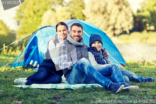 Image of happy family with tent at camp site