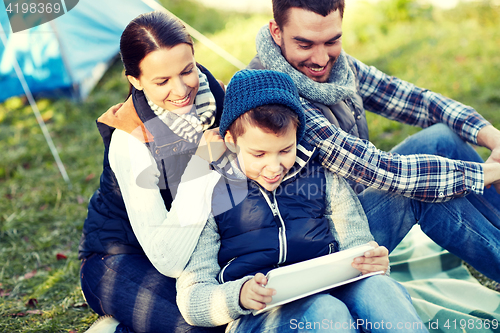 Image of happy family with tablet pc and tent at camp site