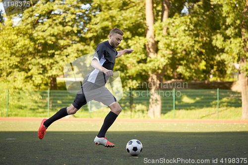 Image of soccer player playing with ball on football field