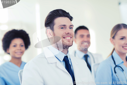 Image of happy doctor over group of medics at hospital