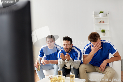 Image of friends or football fans watching soccer at home