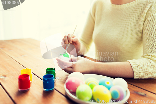 Image of close up of woman hands coloring easter eggs