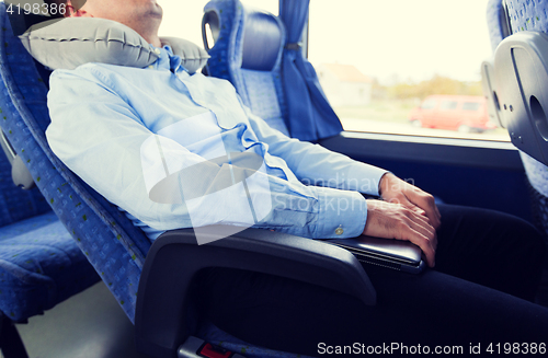 Image of close up of man sleeping in travel bus with pillow