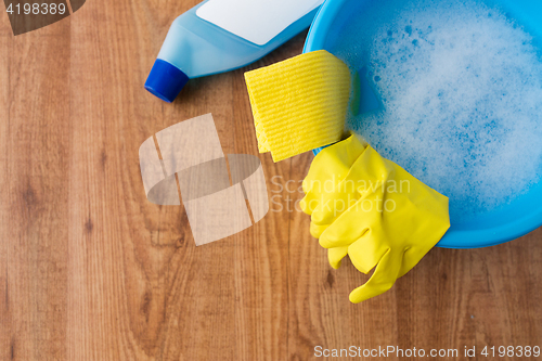 Image of basin with cleaning stuff on wooden background