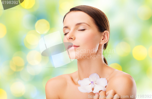 Image of beautiful young woman with orchid flower