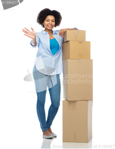 Image of happy african woman with parcel boxes waving hand