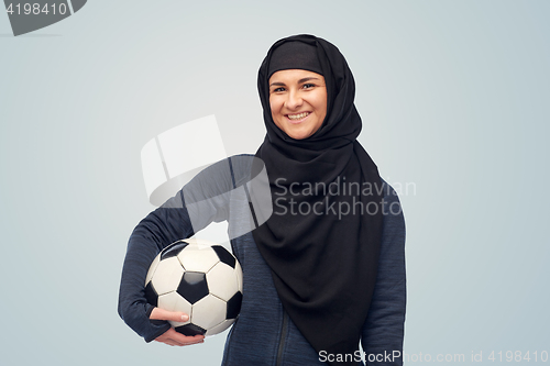 Image of happy muslim woman in hijab with football