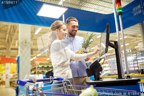 Image of couple buying food at grocery store cash register