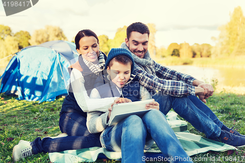 Image of happy family with tablet pc and tent at camp site