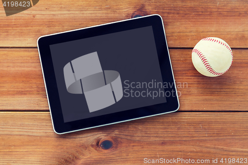 Image of close up of baseball ball and tablet pc on wood