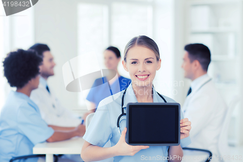 Image of happy doctor over group of medics at hospital