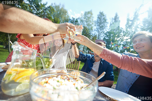 Image of happy friends with drinks at summer garden party