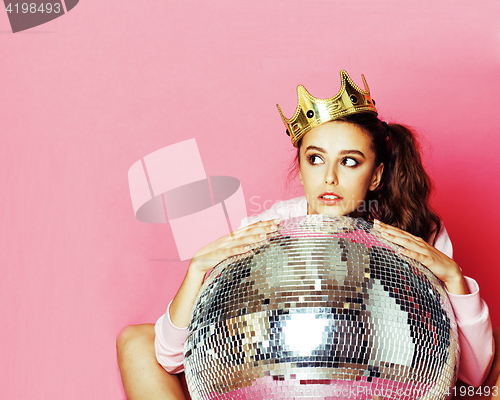 Image of young cute disco girl on pink background with disco ball and cro