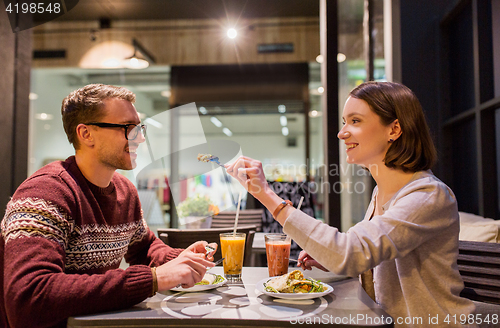 Image of happy couple eating dinner at vegan restaurant