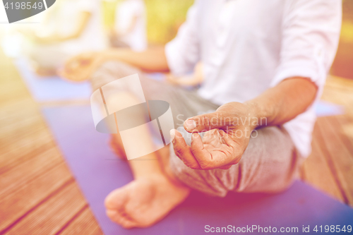 Image of close up of people making yoga exercises outdoors