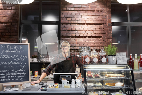 Image of happy seller man or barman at cafe counter