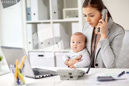 Image of businesswoman with baby calling on phone at office