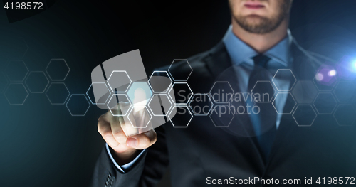 Image of businessman touching virtual hexagonal projection