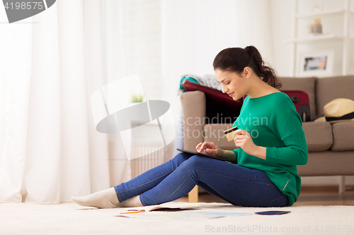 Image of woman with tablet pc and credit card at home