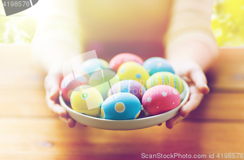 Image of close up of woman hands with colored easter eggs