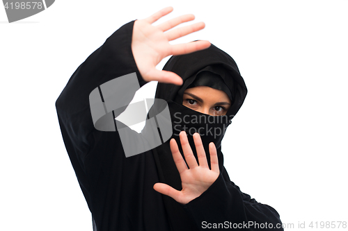 Image of muslim woman in hijab showing stop sign