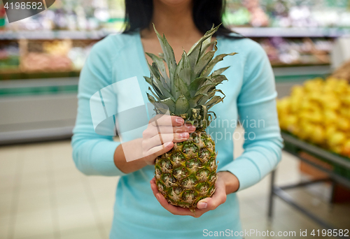 Image of woman with pineapple at grocery store