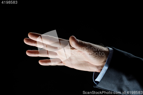 Image of close up of businessman hand over black background