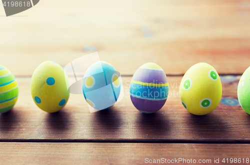 Image of close up of colored easter eggs on wooden surface