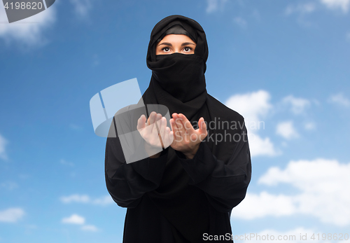 Image of praying muslim woman in hijab over white