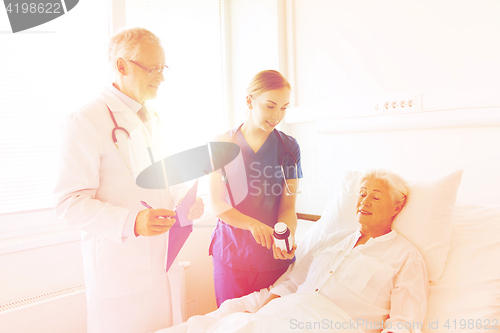 Image of doctor giving medicine to senior woman at hospital