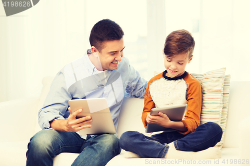 Image of happy father and son with tablet pc at home