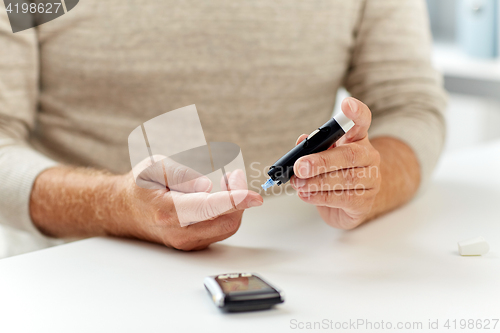 Image of close up of old man with glucometer blood test