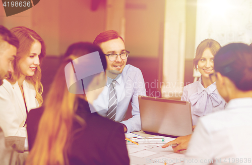 Image of architects with laptop and blueprint at office