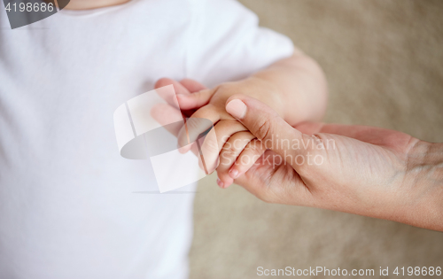 Image of close up of little baby and mother hands