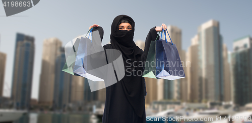 Image of muslim woman in hijab with shopping bags in dubai