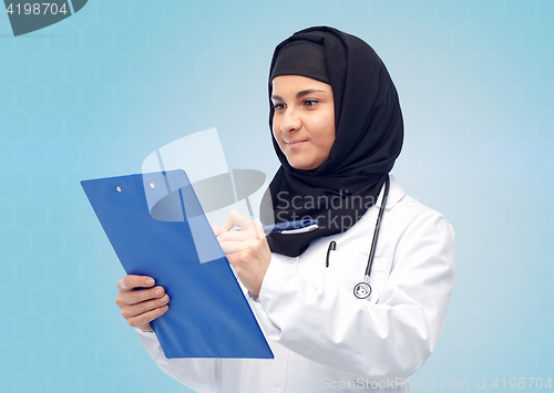 Image of muslim female doctor in hijab with clipboard