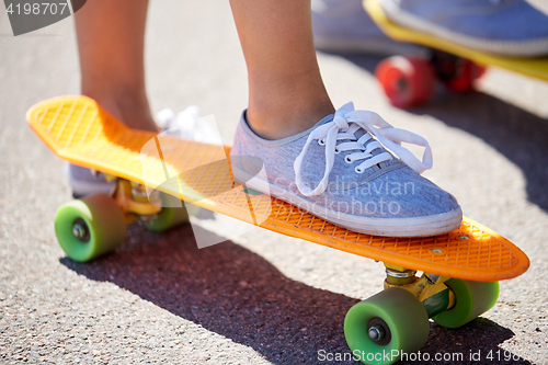 Image of close up of female feet riding short skateboard