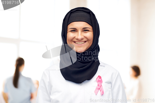 Image of muslim doctor with breast cancer awareness ribbon