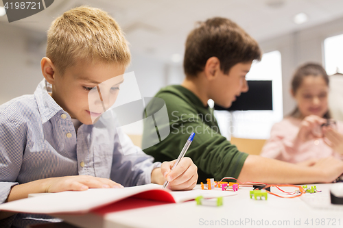 Image of happy children building robots at robotics school