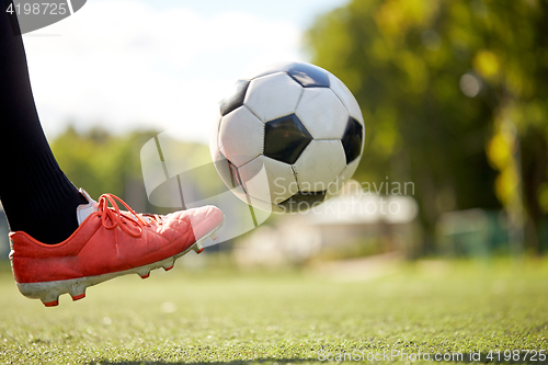 Image of soccer player playing with ball on football field