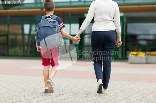 Image of elementary student boy with mother going to school